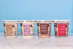Four ice cream containers with labels indicating alcohol flavors: Spiked Espresso Coffee, Batter Up Vodka Martini, Chocolate Whiskey Caramel, and Strawberry Sangria Sorbet.