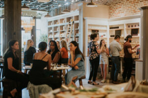 Customers making candles and socializing at Cork and Candles in a warm, inviting space.