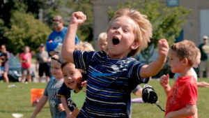 A boy cheers during an outdoor Scoops Lacrosse session.