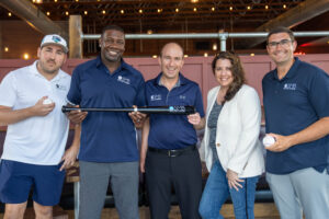 Team members holding sports equipment at SMB event - SMB Franchise Advisors
