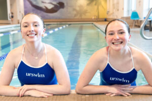 Two smiling swimmers at a poolside - SMB Franchise Advisors