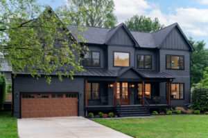 dark grey house exterior that has natural wooden garage doors