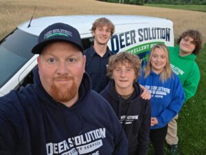Deer Solution franchisees posing by service van.